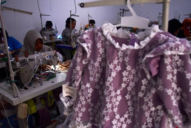 Ilustrasi Pekerja menjahit pakaian di sebuah industri rumahan konveksi di Mancaan, Jiwan, Kabupaten 